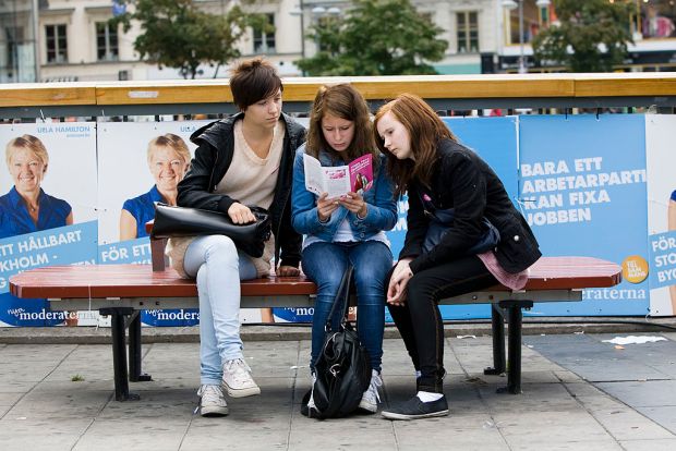 Three young swedish girls read an electi