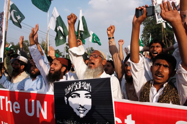 Supporters of the Islamic charity organization Jamaat-ud-Dawa (JuD) hold a picture of Hizbul Mujahideen commander Burhan Muzaffar Wani and national flags during a demonstration in Faisalabad